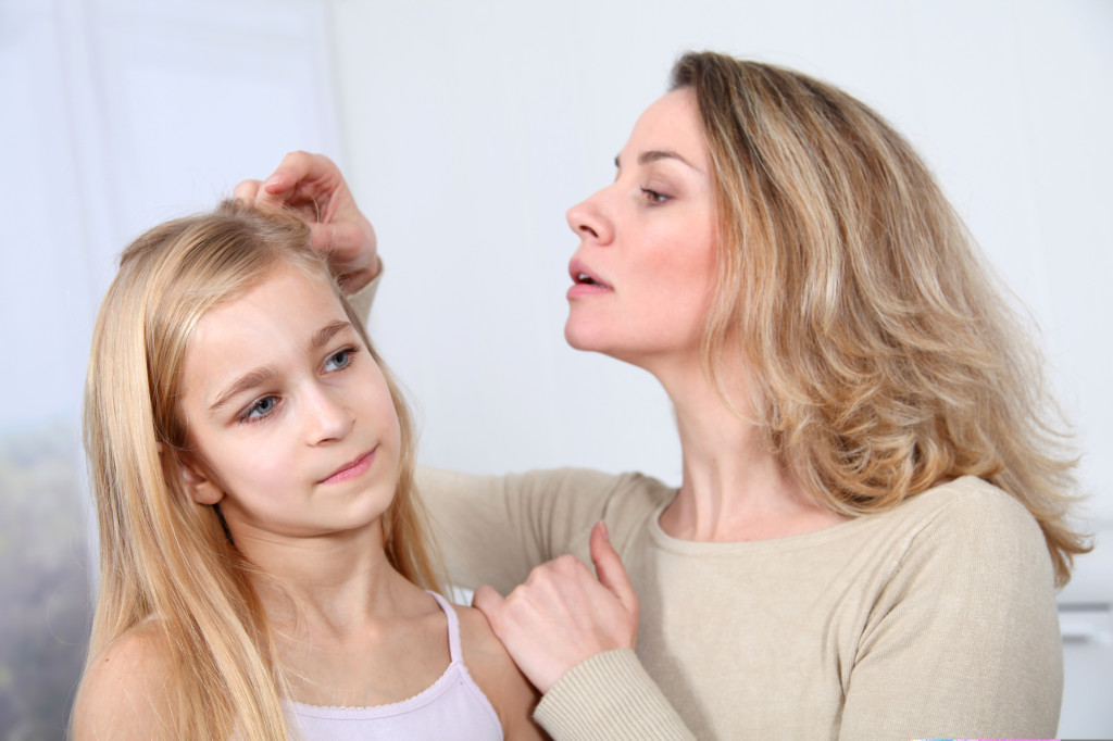 Mother treating daughter's hair against lice